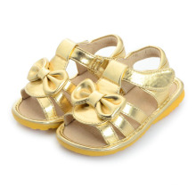 Sandálias de bebê de ouro com arco lindo